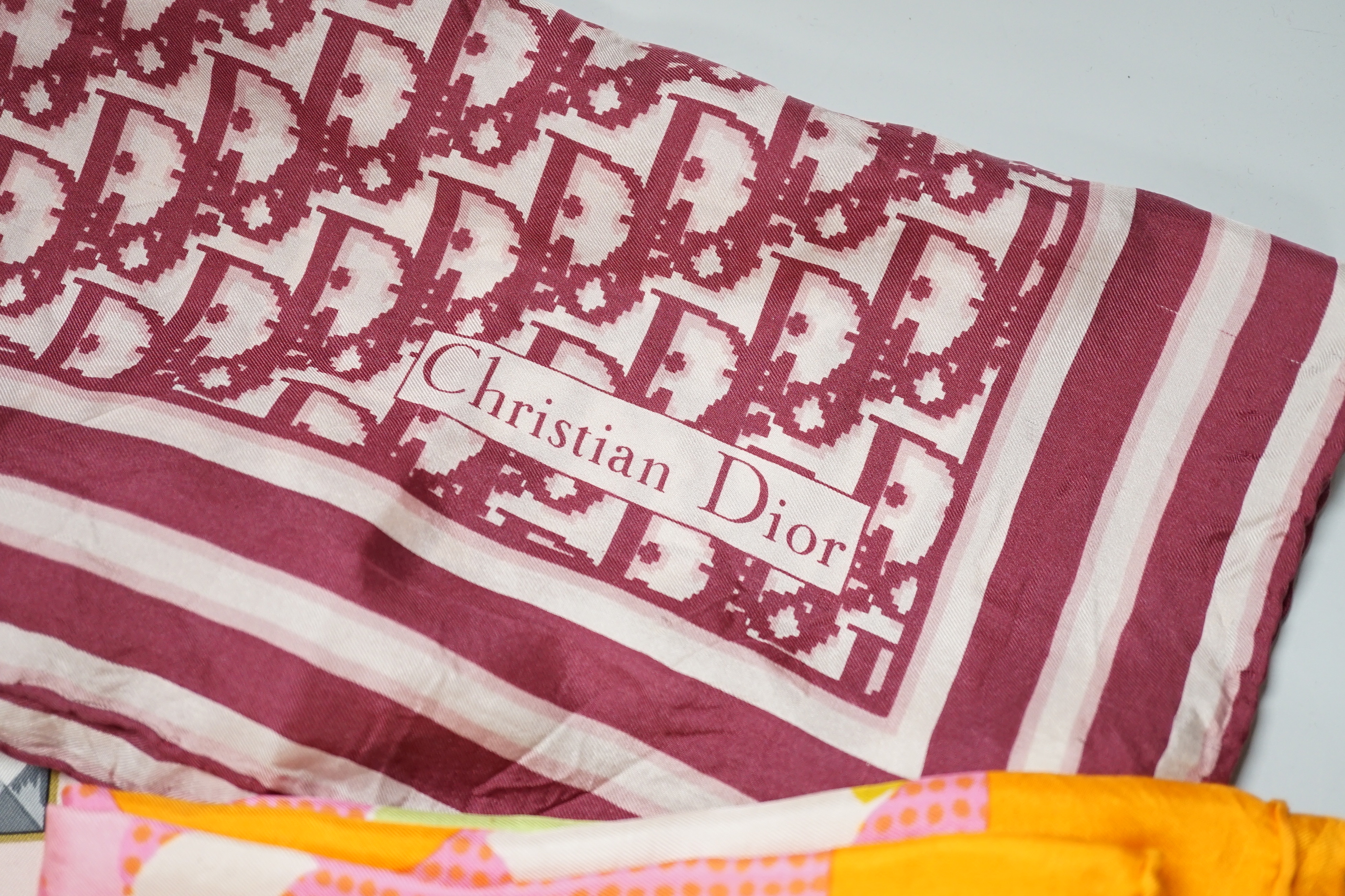A Hermes, Paris silk scarf “Les Cles Bordeaux” with pink border and three Christian Dior silk scarves